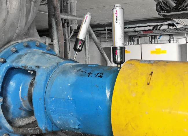 Two simalube IMPULSE automatically and continuously lubricate the bearings of a pump via a long hose.