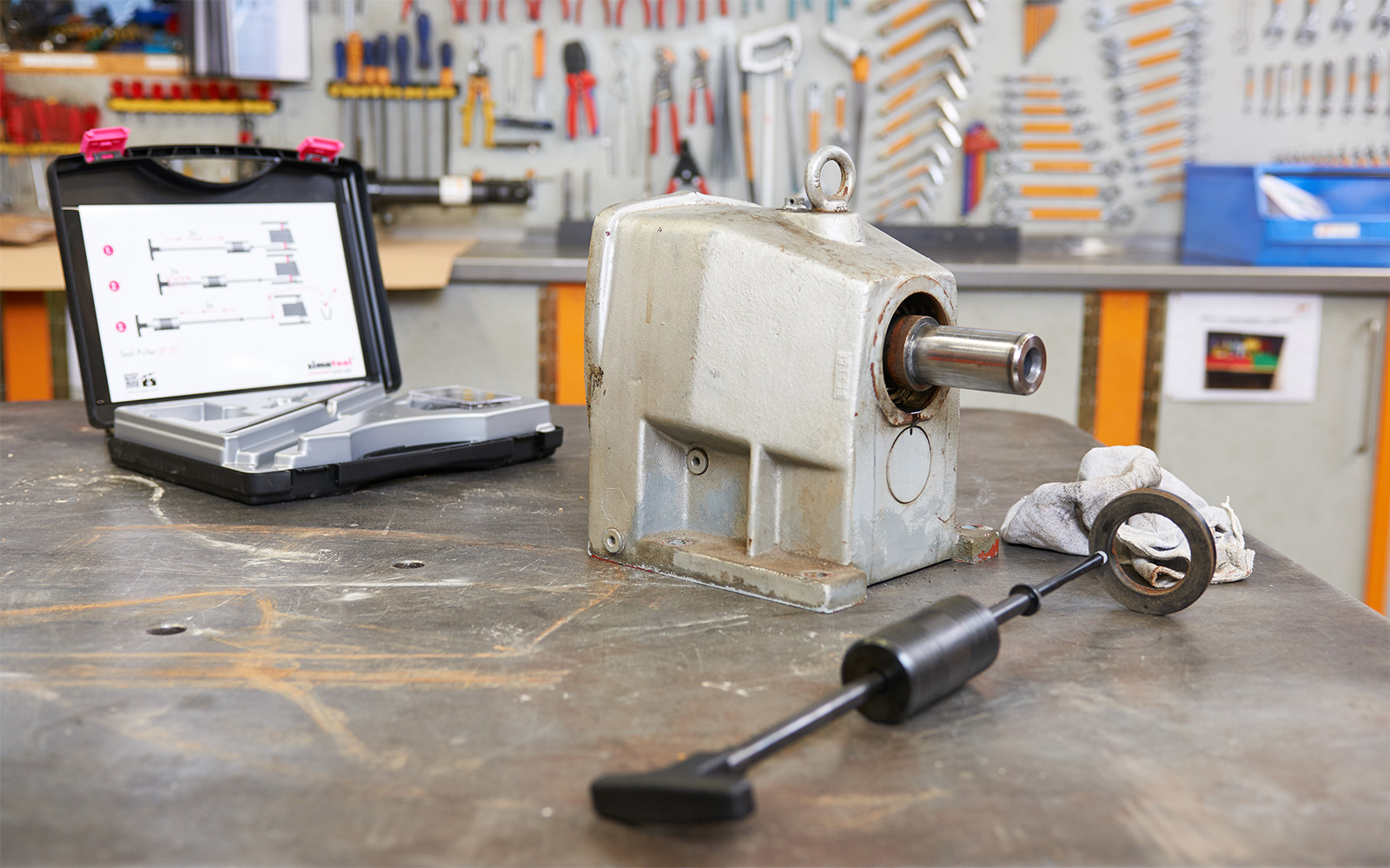 A shaft seal is removed from a gearbox in a workshop with the help of the seal puller.