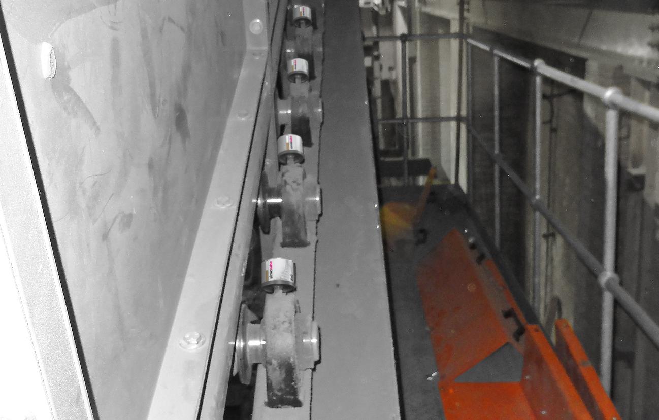 Several simalube 30 ml lubricators automatically lubricate a conveyor belt.